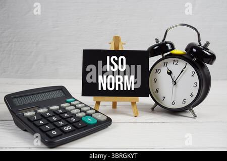 Testo DELLA NORMA ISO con sveglia su sfondo in legno Foto Stock