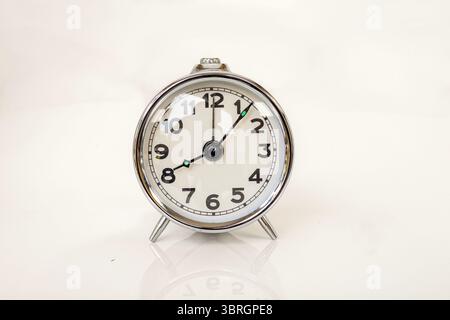 Classica sveglia Chrome Vintage che mostra le 8:00 isolata su sfondo bianco con spazio copia Foto Stock