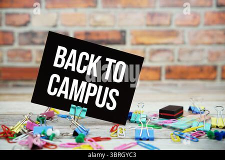 Torna al testo del Campus su una scheda di carta fissa su sfondo in legno Foto Stock