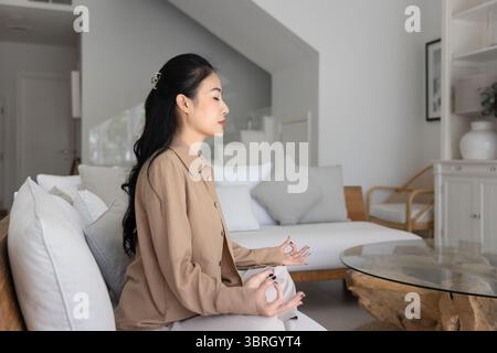 Vista laterale del profilo della donna vietnamita serena fare pratica di meditazione Foto Stock