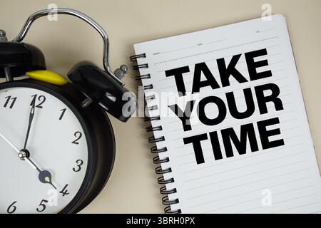 Prendete il testo del vostro tempo scritto sul blocco note con la sveglia Foto Stock