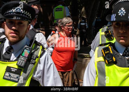 Londra, Regno Unito. 12 luglio 2025. Gli agenti della polizia metropolitana arrestano un manifestante che aveva tenuto un cartello con la scritta "io mi oppongo al genocidio - sostengo l'azione palestinese” in piazza del Parlamento. E' stata la seconda protesta di questo tipo in Piazza del Parlamento organizzata dal gruppo di campagna difendere le nostre giurie da quando il Parlamento britannico ha votato per vietare il gruppo di azione diretta Palestina Action come organizzazione terroristica a partire dal 5 luglio 2025. Proteste simili si sono svolte altrove nel Regno Unito. Tutti i manifestanti che hanno dei segni sono stati arrestati ai sensi del Terrorism Act 2000 con il sospetto di sostenere un'organizzazione proibita e ora possono f Foto Stock