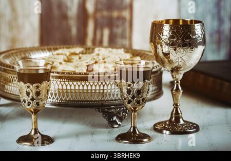 La santa comunione sulla tavola di legno in chiesa a tazza di vetro con il vino rosso, il pane e la Santa Bibbia Foto Stock