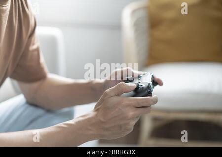 Giovane uomo asiatico controller di gioco console video giocare tenendo hobby giocoso Video gioco online divertimento eSport Cyber Games Internet Foto Stock