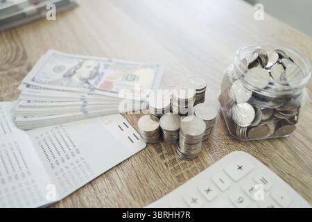 Primo piano delle monete e delle banconote in dollari che consentono di risparmiare denaro sul concetto di banca finanziaria Foto Stock