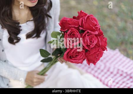 Felice coppia romantica a San Valentino con rose rosse appuntamento romantico picnic Foto Stock