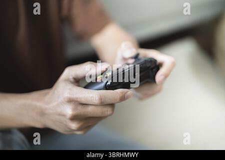 Giovane uomo asiatico controller di gioco console video giocare tenendo hobby giocoso Video gioco online divertimento eSport Cyber Games Internet Foto Stock