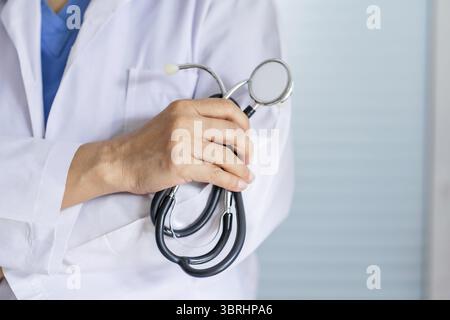 Medico donna asiatica anziana che indossa occhiali e uniforme con stetoscopio in Hand Healthcare e concetto medico Foto Stock