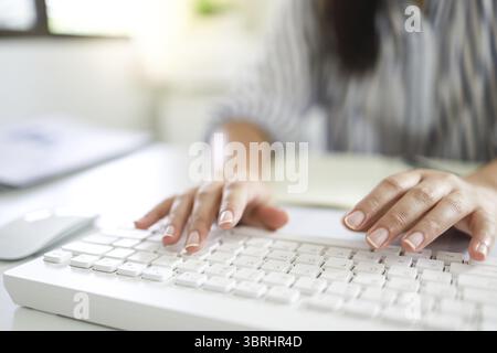 Digitazione manuale sulla tastiera. scrivere un blog. Donna mette le mani sulla tastiera che lavora a casa. le mani sono in macchina da scrivere Foto Stock