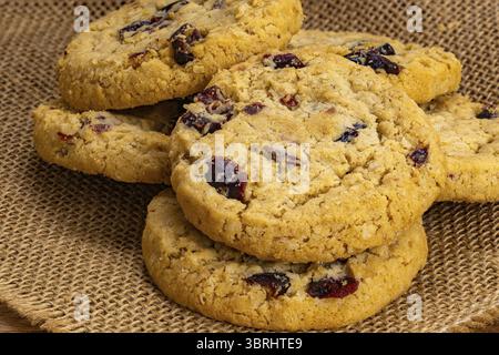 Pile di fiocchi d'avena circolari fatti in casa e biscotti al mirtillo su un panno per sacco Foto Stock
