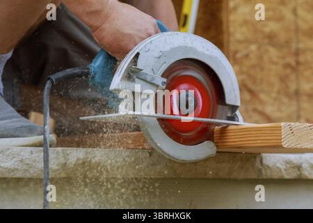 Carpenter utilizzando una sega circolare per la trave di legno un nuovo home progetto constructiion Foto Stock