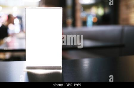 Telaio di menu in piedi sulla tavola di legno nel bar ristorante cafe. spazio per il testo marketing promozione Foto Stock
