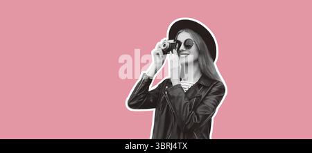 Elegante giovane fotografa che scatta foto con la macchina fotografica che indossa un cappello rotondo nero e una giacca in pelle rock che guarda lontano su un backgroun rosa Foto Stock
