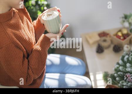 Donna che regge una tazza di cacao aromatico con marshmallow. La vigilia di Natale con una tazza di gustosa cioccolata calda atmosfera accogliente per le vacanze a casa Foto Stock