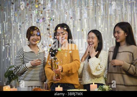 Amici allegri che si divertono con la festa di compleanno a casa. Amici asiatici che festeggiano Foto Stock