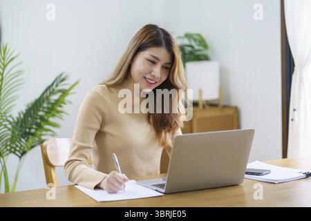 Felice bella donna asiatica. Donna d'affari che lavora da casa con il concetto di spazio di lavoro Financial Home Foto Stock