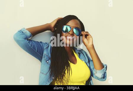 Ritratto di una giovane donna africana elegante con dreadlock che si posa in posa indossando casual in città Foto Stock