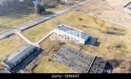 Vista aerea di un'area industriale abbandonata con vecchi edifici e vegetazione sovrastata. Foto Stock