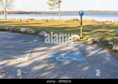 Posto auto vuoto riservato ai disabili in un parco pubblico costiero in una giornata di sole d'autunno Foto Stock
