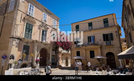TROPEA, ITALIA - 2 GIUGNO 2025 - turisti che camminano in una piazza di Tropea, Calabria, circondata da edifici storici e bouganville colorate Foto Stock