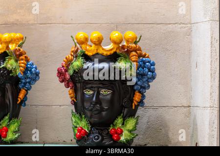 Arte popolare siciliana, vasi di fiori tradizionali a forma di teste di uomo e donna, colorate ceramiche dipinte a mano, splendido souvenir per i turisti Foto Stock