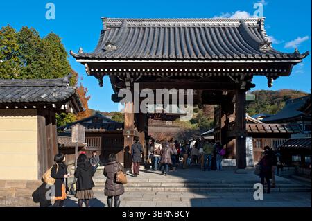 I visitatori passano attraverso la porta principale Kenchoji (建長寺) Somon (総門) del tempio buddista Zen a Kamakura, Kanagawa, Giappone. Foto Stock