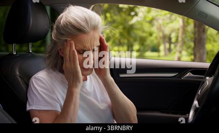 Stressata preoccupata sofferenza caucasica anziana anziana donna malsana anziana donna autista donna che tiene testa massaggiante templi soffrono mal di testa Foto Stock