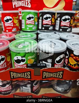 Vienna, Austria - 12. Luglio 2025: Lattine colorate di Pringles impilate su uno scaffale del supermercato, che mostrano sapori diversi e il logo iconico Foto Stock