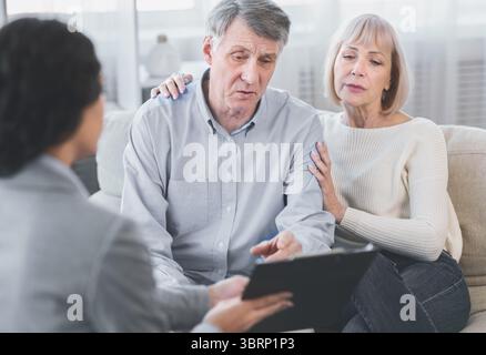 Coppia senior che parla con il loro consulente finanziario Foto Stock