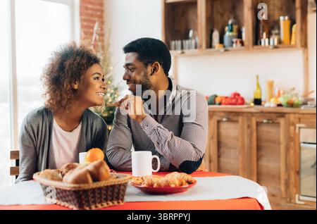 African-american giovane godendo gustosi biscotti in cucina Foto Stock