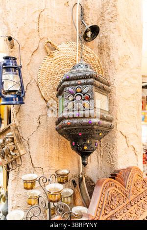 Lampada tradizionale araba d'epoca con vetrate colorate e decorazioni a specchio, lampada antica appesa sullo sfondo della vecchia parete Foto Stock