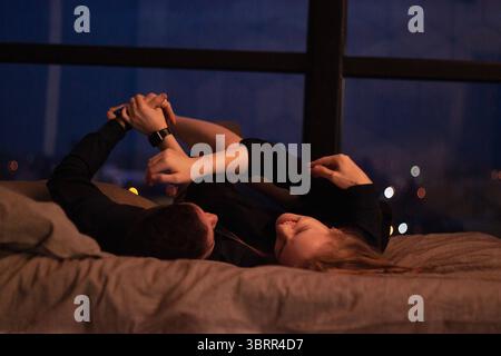 Una coppia abbraccia tenerezza in un ambiente caldo e romantico con illuminazione soffusa, perfetto per l'intimità Foto Stock