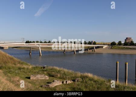 L'elegante ponte Lentloper attraversa il fiume Waal a Nijmegen, nei Paesi Bassi, mostrando infrastrutture moderne contro un cielo azzurro e limpido Foto Stock