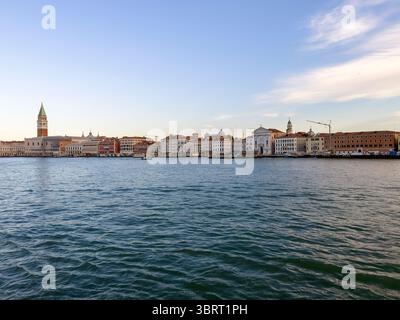 L'ingresso a Venezia, Italia, con le barche in arrivo e gli edifici storici che costeggiano il lungomare all'alba. Foto Stock