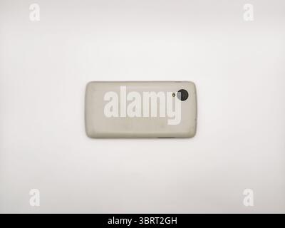 Un cellulare bianco si trova su una superficie bianca. copia spazio, flay lay, vista dall'alto. Manca il retro del telefono. Il telefono non è in uso Foto Stock