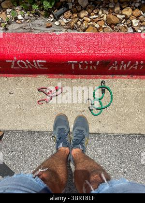 27 maggio 2025 - Austin, Texas, Stati Uniti - i marciapiedi dipinti rossi di una zona di traino senza parcheggio su una superstrada, in piena luce del sole. Foto Stock