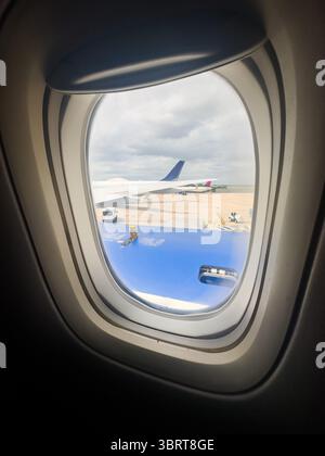 26 MAGGIO 2025 - Austin, Texas - Una vista dall'oblò di un aereo, guardando la pista e la logistica di carico Foto Stock