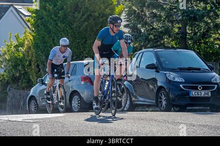 I concorrenti di Swansea Ironman salgono su una ripida collina nel caldo mattutino, partecipando alla famosa gara di triathlon che si fa strada passando per i Giardini di Thistleboon nella sezione Mumbles del percorso di Swansea. Foto Stock