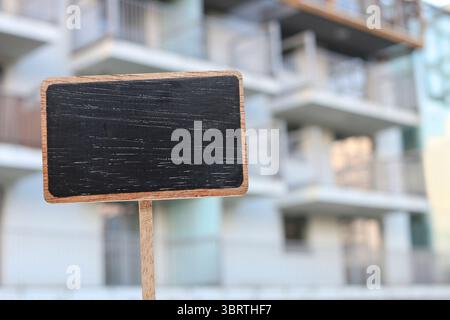 Etichetta della lavagna e un condominio sullo sfondo, spazio per le copie Foto Stock