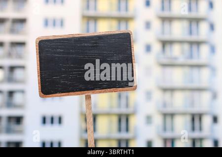 Etichetta della lavagna e un condominio sullo sfondo, spazio per le copie Foto Stock
