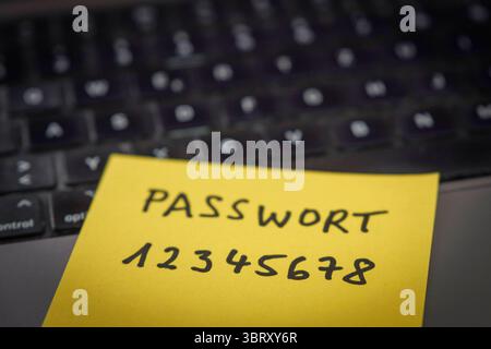 Sicherheitsrisiko auf dem Schreibtisch: Ein Zettel mit dem unsicheren Passwort 12345678 liegt offen auf einem laptop, ein klassisches Beispiel für fahrlässigen Umgang mit sensiblen Zugangsdaten. *** Rischio di sicurezza sulla scrivania: Un pezzo di carta con la password non sicura 12345678 aperta su un laptop è un classico esempio di gestione negligente dei dati di accesso sensibili. Nordrhein-Westfalen Deutschland, Germania GMS19540 Foto Stock