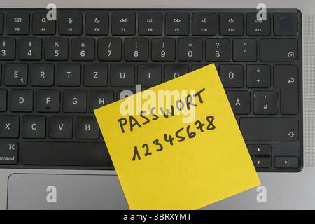 Sicherheitsrisiko auf dem Schreibtisch: Ein Zettel mit dem unsicheren Passwort 12345678 liegt offen auf einem laptop, ein klassisches Beispiel für fahrlässigen Umgang mit sensiblen Zugangsdaten. *** Rischio di sicurezza sulla scrivania: Un pezzo di carta con la password non sicura 12345678 aperta su un laptop è un classico esempio di gestione negligente dei dati di accesso sensibili. Nordrhein-Westfalen Deutschland, Germania GMS19543 Foto Stock