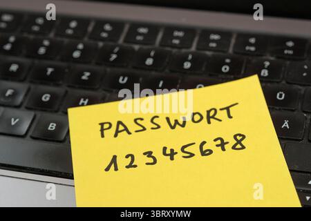 Sicherheitsrisiko auf dem Schreibtisch: Ein Zettel mit dem unsicheren Passwort 12345678 liegt offen auf einem laptop, ein klassisches Beispiel für fahrlässigen Umgang mit sensiblen Zugangsdaten. *** Rischio di sicurezza sulla scrivania: Un pezzo di carta con la password non sicura 12345678 aperta su un laptop è un classico esempio di gestione negligente dei dati di accesso sensibili. Nordrhein-Westfalen Deutschland, Germania GMS19544 Foto Stock