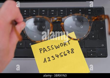 Sicherheitsrisiko auf dem Schreibtisch: Ein Zettel mit dem unsicheren Passwort 12345678 liegt offen auf einem laptop, ein klassisches Beispiel für fahrlässigen Umgang mit sensiblen Zugangsdaten. *** Rischio di sicurezza sulla scrivania: Un pezzo di carta con la password non sicura 12345678 aperta su un laptop è un classico esempio di gestione negligente dei dati di accesso sensibili. Nordrhein-Westfalen Deutschland, Germania GMS19546 Foto Stock