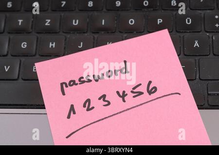 Sicherheitsrisiko auf dem Schreibtisch: Ein Zettel mit dem unsicheren Passwort 123456 liegt offen auf einem laptop, ein klassisches Beispiel für fahrlässigen Umgang mit sensiblen Zugangsdaten. *** Rischio di sicurezza sulla scrivania: Un pezzo di carta con la password non sicura 123456 aperta su un laptop è un classico esempio di gestione negligente dei dati di accesso sensibili. Nordrhein-Westfalen Deutschland, Germania GMS19549 Foto Stock