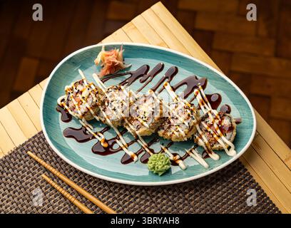 Sushi roll tempura steso sul piatto con wasabi e zenzero Foto Stock
