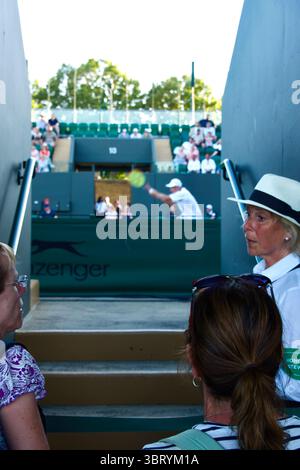 Ufficiale femminile che parla con i tifosi in attesa di una pausa in gioco all'ingresso di un campo All England Tennis Club Wimbledon Londra Inghilterra Regno Unito Foto Stock
