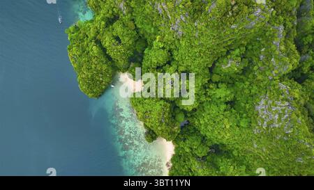 Vista aerea della spiaggia nascosta con acque turchesi che incontrano lussureggianti scogliere verdi, l'isola di Phi Phi, il quartiere di Mueang Krabi, Thailandia. Foto Stock