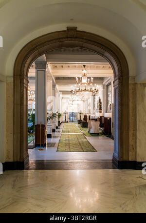 San Antonio, Texas - 27 febbraio 2025: Un elegante corridoio del St. Anthony Hotel caratterizzato da lampadari decorati e architettura classica Foto Stock