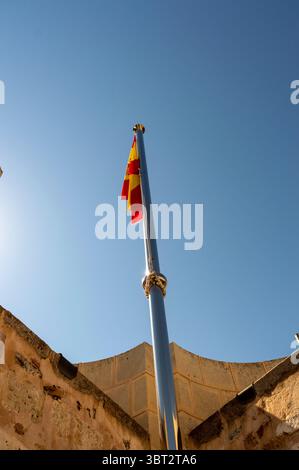 Palo di metallo con la bandiera della Spagna sulla parte più alta di una torre del castello. Foto Stock